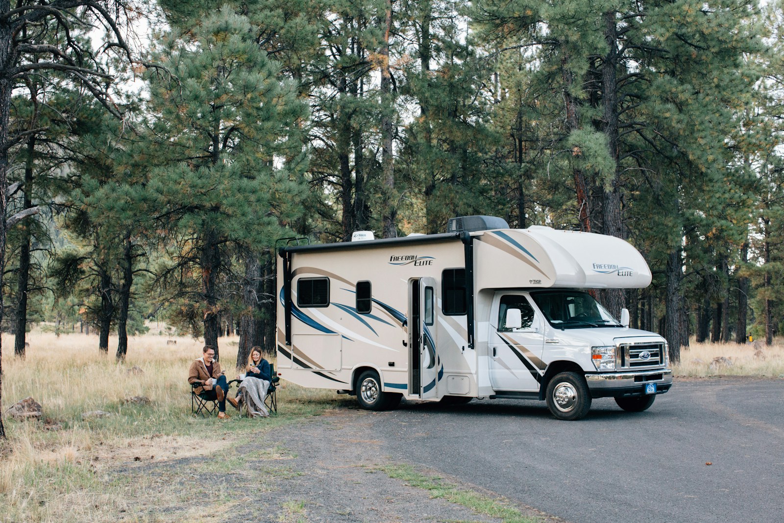 people standing near white rv trailer during daytime, rv